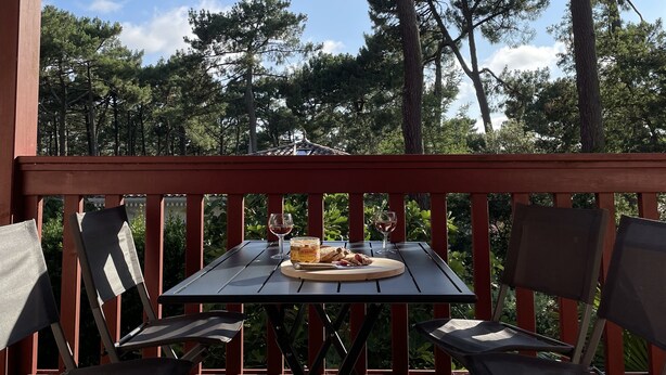 A wooden deck with a table and chairs, overlooking a forested area. - 2 bedrooms, 2 bathrooms appartement with terrace and balcony, close to beaches (Arcachon)