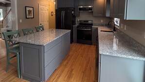 Una cucina moderna con piani di lavoro in granito, elettrodomestici in acciaio inossidabile e mobili in grigio.