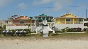 A row of three houses with a central staircase leading to a porch. - Cassaruina Studio 3 (Rolleville)