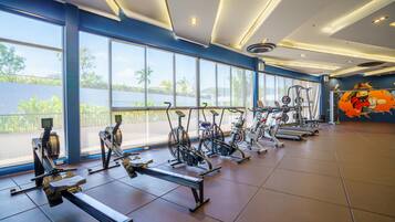 A gym with exercise equipment, large windows, and a view of the outdoors.
