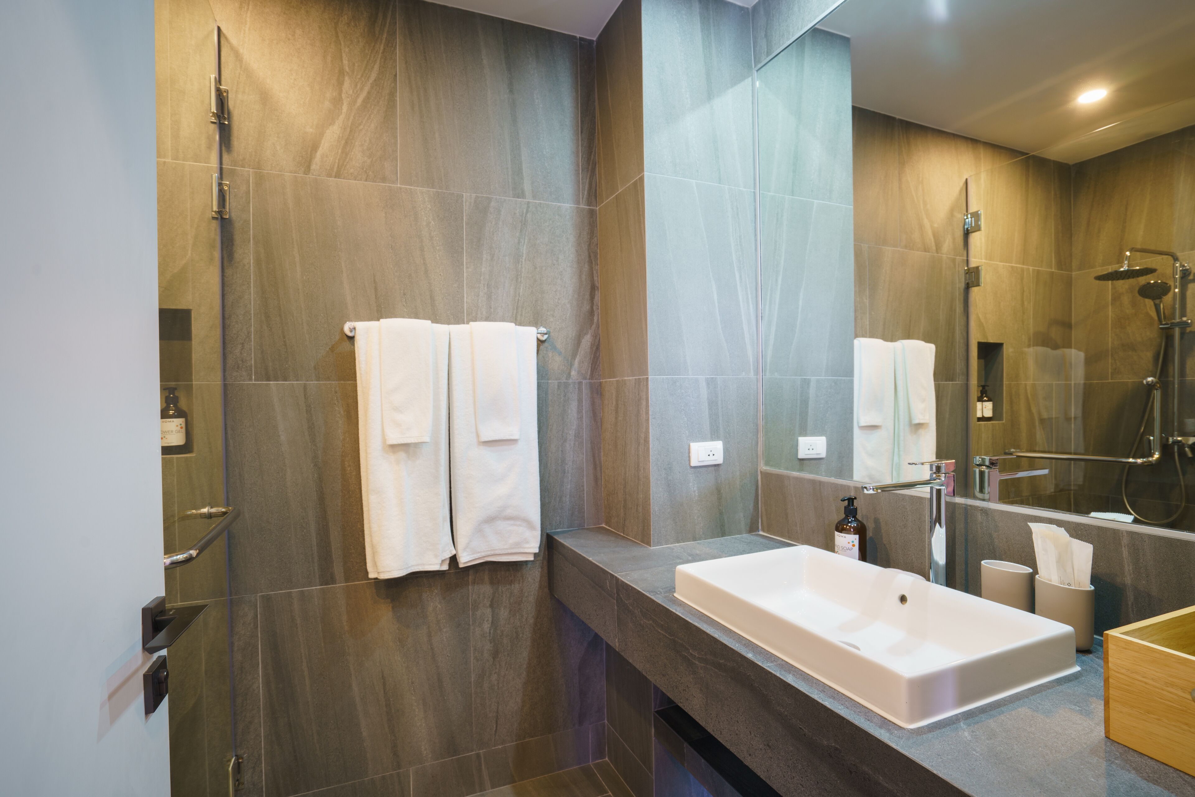 A modern bathroom with a large bathtub, a shower, and a vanity with a mirror.