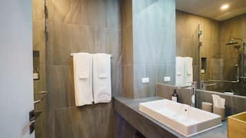 Un baño moderno con una bañera grande, ducha y tocador con espejo.