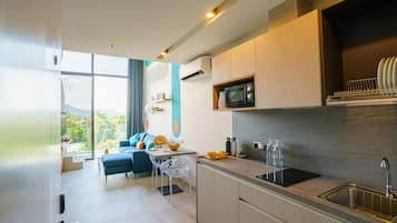 Una cocina moderna con microondas integrado, pileta de acero inoxidable y un comedor con mesa y sillas.