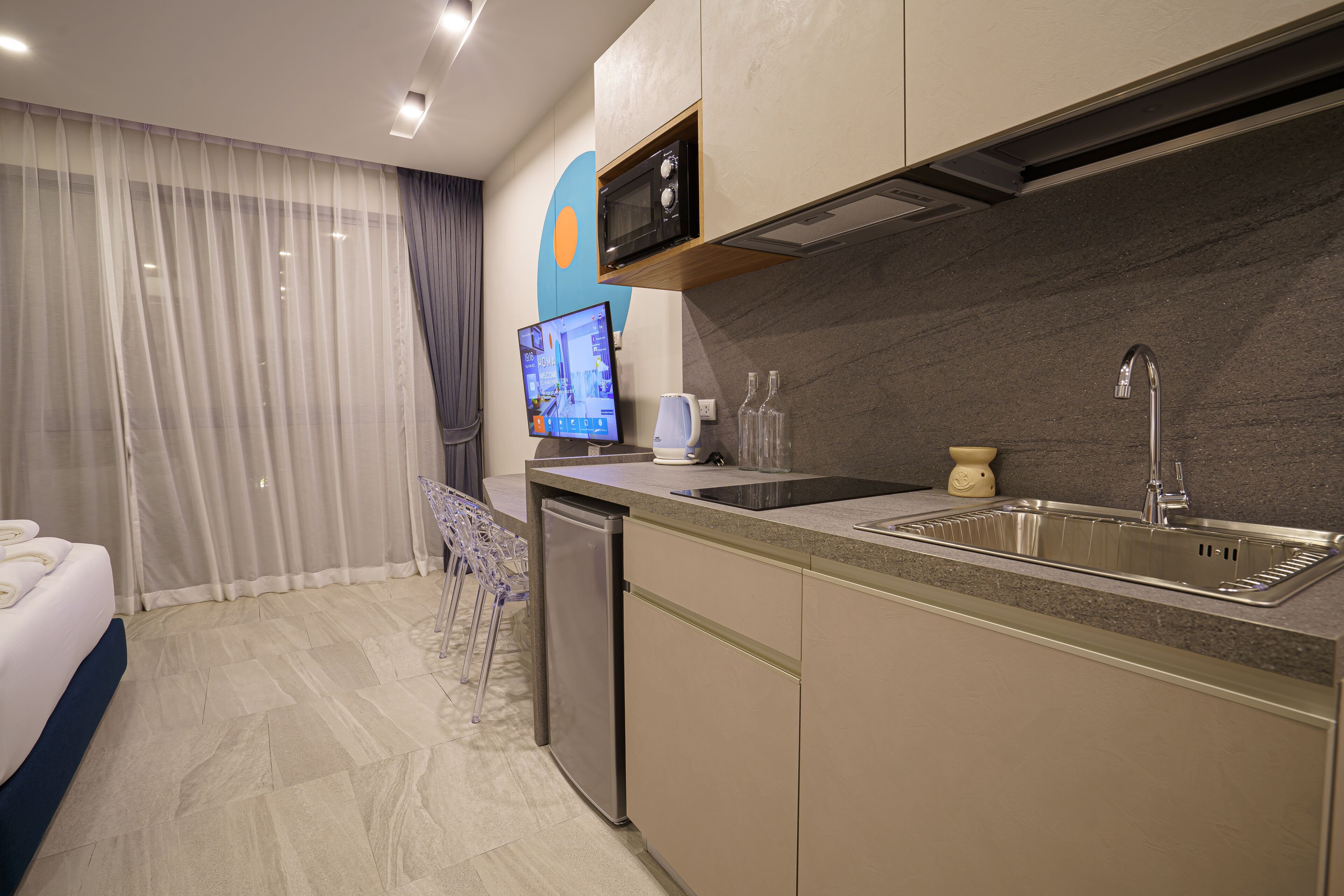A modern kitchen with a built-in microwave, a stainless steel sink, and a dishwasher.