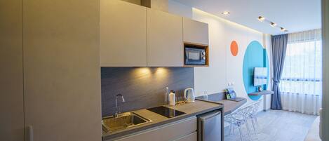 A modern kitchen with a built-in microwave, stainless steel sink, and a compact dishwasher.