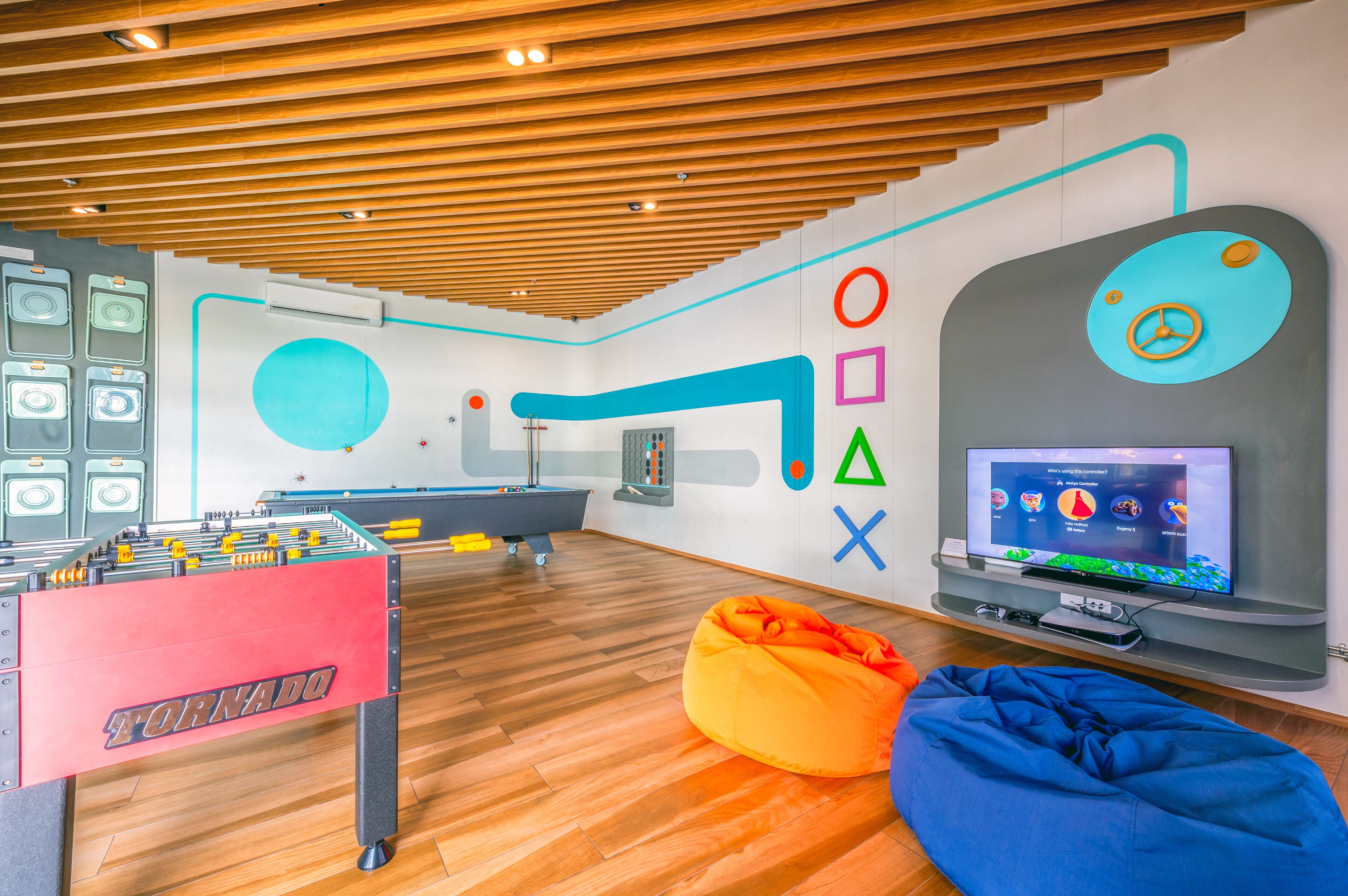 Una habitación moderna con mesa de fútbol, televisor y mesa de billar.