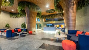 A spacious lobby with modern seating, a reception desk, and indoor plants. - HOMA Phuket Town (Ratsada)