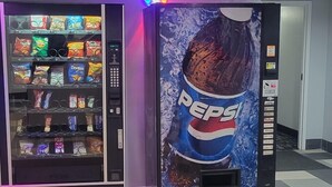 Ein Getränkeautomat mit einer Pepsi-Werbung und ein weiterer Automat mit Snacks.