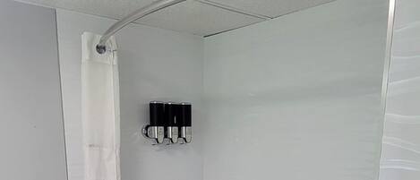 Une salle de bain avec des toilettes, une baignoire et un rideau de douche.