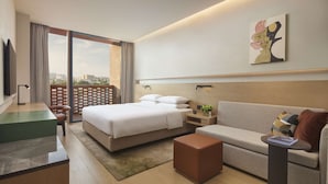 A modern hotel room with a bed, a sofa, a desk, and a large window offering a city view. - Hyatt Place Jingdezhen Taoxichuan (Jingdezhen)
