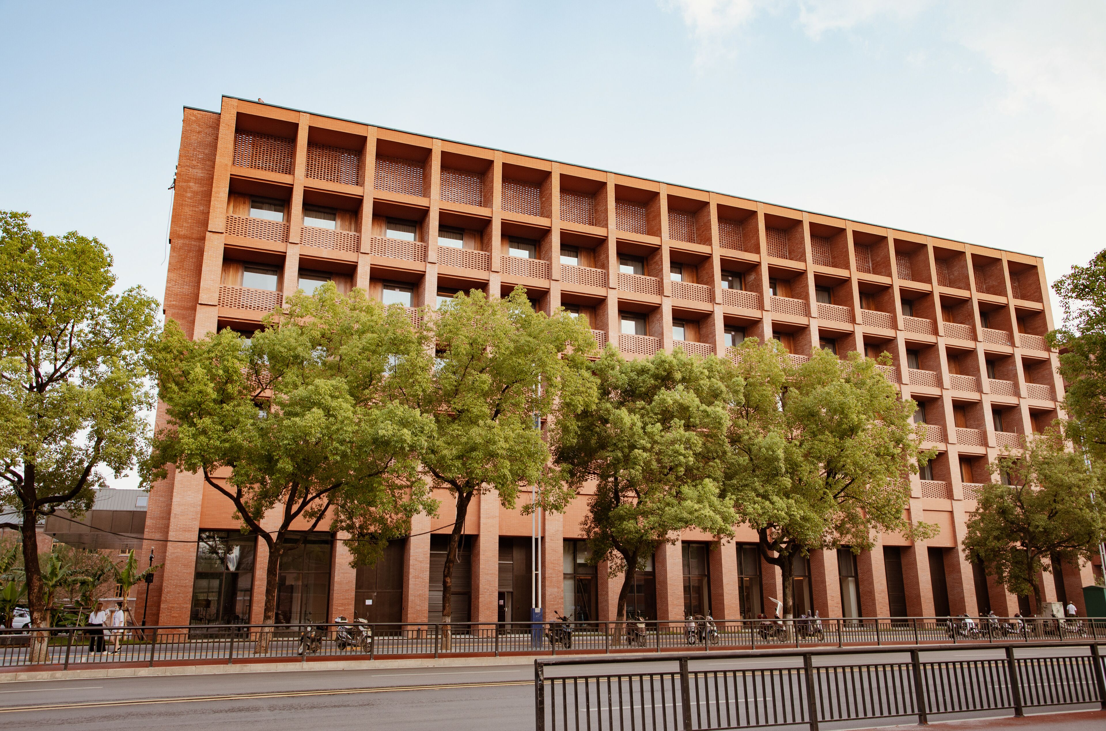 A multi-story building with a brick facade, large windows, and balconies.