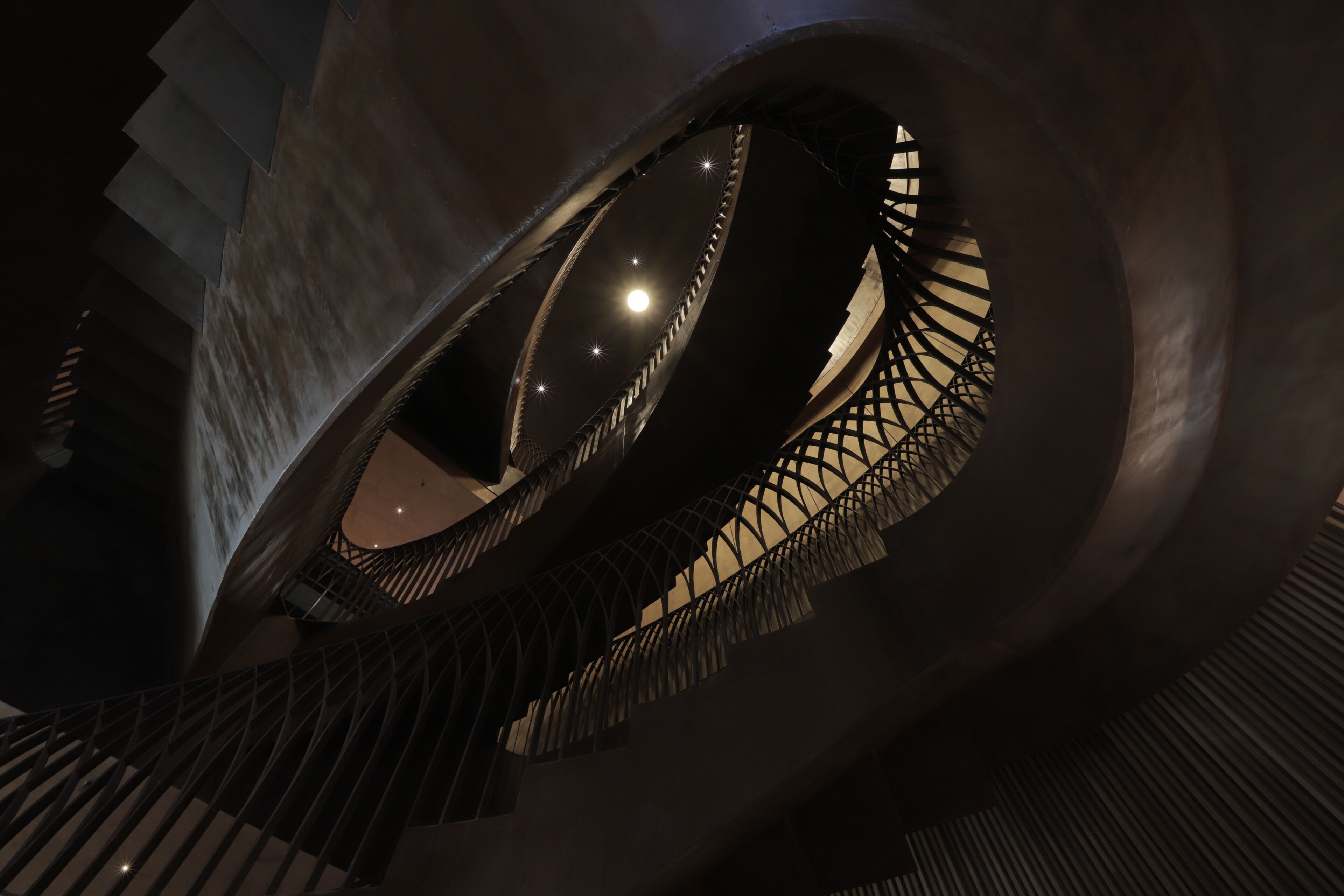 A spiral staircase with a circular viewing platform, metal railings, and a modern architectural design.