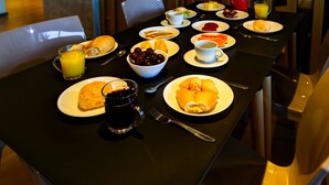 A breakfast table set with plates of food, including eggs, toast, and fruit, along with beverages and cutlery. - Transamerica Fit Lucas Do Rio Verde (Lucas do Rio Verde)