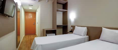 Habitación de hotel con dos camas, televisión, armario y escritorio.