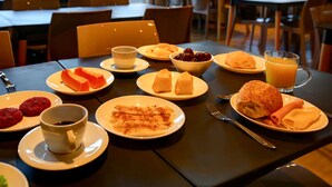 A breakfast setting with various dishes, including pastries, fruits, and a glass of orange juice. - Transamerica Fit Lucas Do Rio Verde (Lucas do Rio Verde)