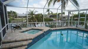 A swimming pool with a built-in hot tub and a small waterfall feature. - Palm Tree III Pool Home Waterfront  (Apollo Beach)
