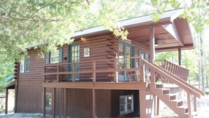 A log cabin with a balcony and a staircase leading to the upper level. - Log Cabin 2 at Osborn Boat Ramp on Patoka Lake (Jackson Township)