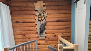 A wooden interior with a metal staircase, a wall-mounted decorative piece, and a door. - Log Cabin 2 at Osborn Boat Ramp on Patoka Lake (Jackson Township)
