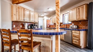 Una cucina con mobili in legno, un'isola con piastrelle blu e un tavolo da pranzo in legno con sedie.