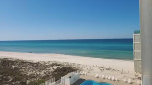 A beach view with a pool and lounge chairs. - Beachfront Studio • Gulf Views • Pool • Walk to Beach + Dining (Panama City Beach)