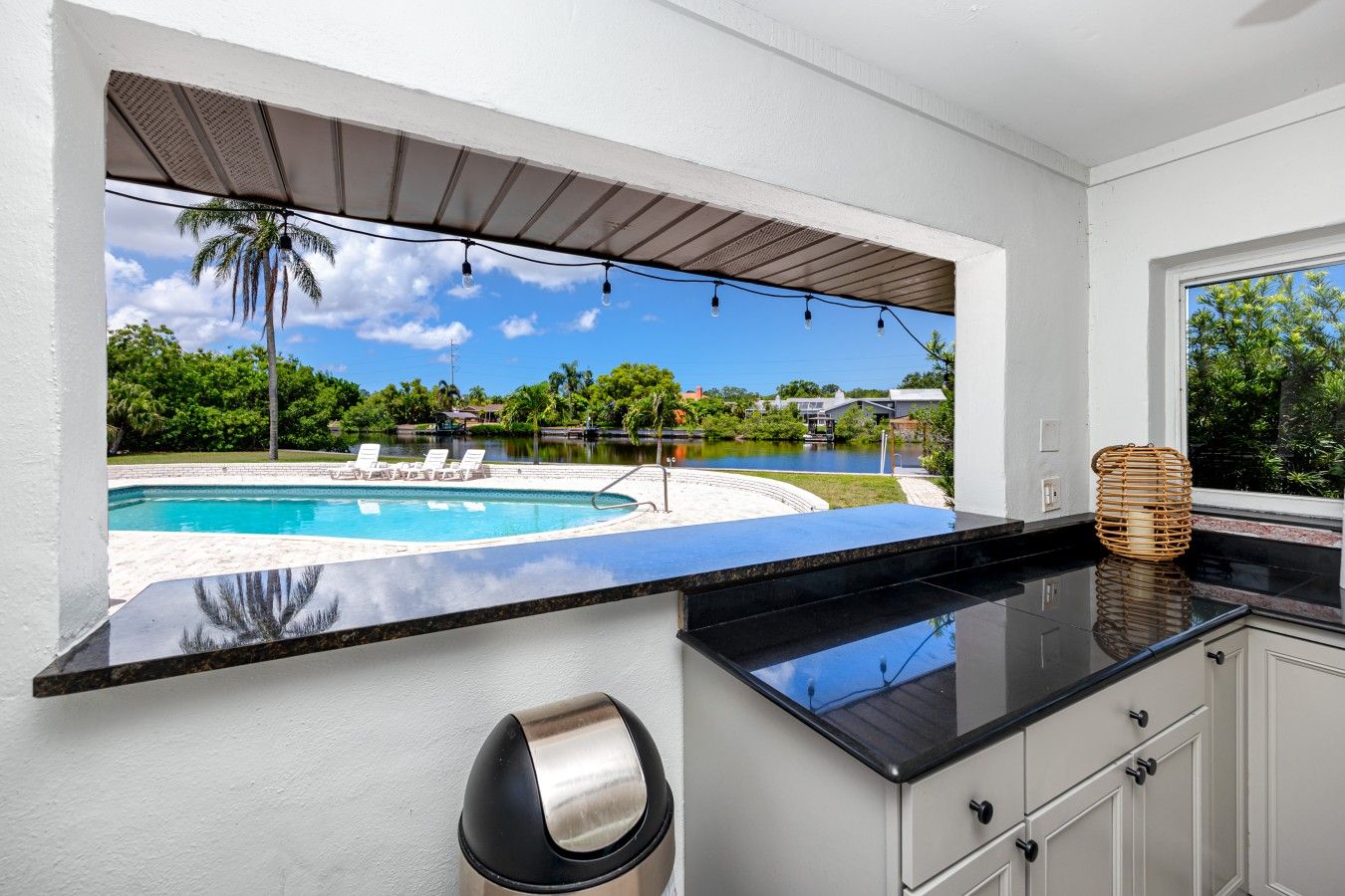 Una cocina con vista a una piscina y palmeras.