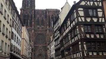 A historic town square with Gothic architecture, including a cathedral and half-timbered buildings.