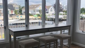A kitchen with a large window overlooking a dock and houses.