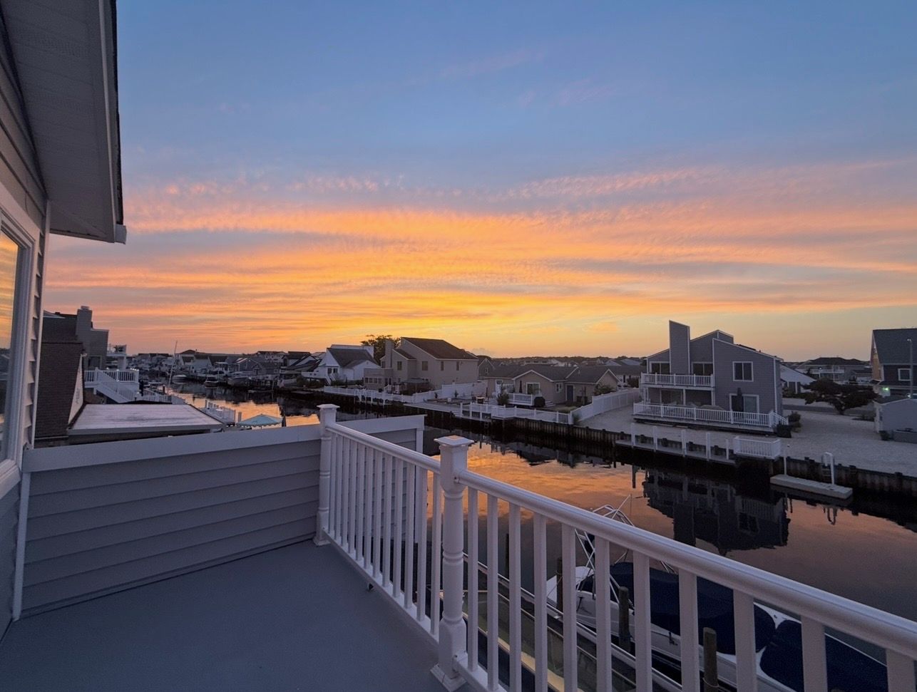 A waterfront property with a balcony overlooking a marina and residential buildings.
