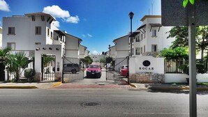 A gated entrance to a residential area with a red car parked in front. - 5 Min Driving to he Beach, 6 People, 5 Beds, Pool, wifi (Playa del Carmen)