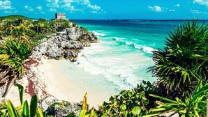 A beach with clear turquoise waters, a sandy shore, and a stone structure on a cliff. - 5 Min Driving to he Beach, 6 People, 5 Beds, Pool, wifi (Playa del Carmen)