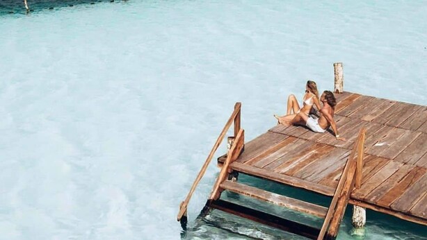 A wooden dock extending into a clear turquoise sea with a couple sitting on it. - 5 Min Driving to he Beach, 6 People, 5 Beds, Pool, wifi (Playa del Carmen)