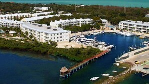 A marina with boats, a pier, and a resort with multiple buildings. - Key Largo Luxury Townhome | Pools & Marina (Key Largo)