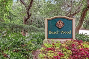 A sign with the name 'Beach Wood' surrounded by lush greenery.