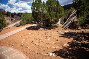 A landscaped area with a circular pattern of rocks and a paved path leading through it.