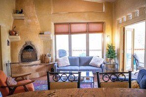 A cozy living room with a fireplace, a sofa, and a coffee table. - Mountain Adobe Home in Jemez Springs NEW HOT TUB, Mt. Views "Raven House" (Jemez Springs)