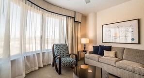 A hotel room with a large window, a patterned armchair, a sofa, a side table with a lamp, and a framed abstract artwork on the wall. - Bluegreen Club 36, 2 Bedroom Condo, Free WiFi & Parking (Las Vegas)