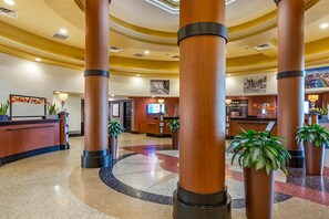 A hotel lobby with a reception desk, large wooden columns, and potted plants. - Bluegreen Club 36, 2 Bedroom Condo, Free WiFi & Parking (Las Vegas)