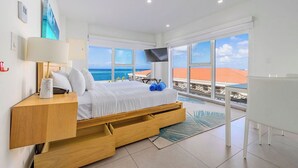 Een moderne slaapkamer met een bed, nachtkastje en uitzicht op zee.