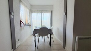 Ein schmaler Flur, der zu einem Essbereich mit Tisch und Stühlen führt.