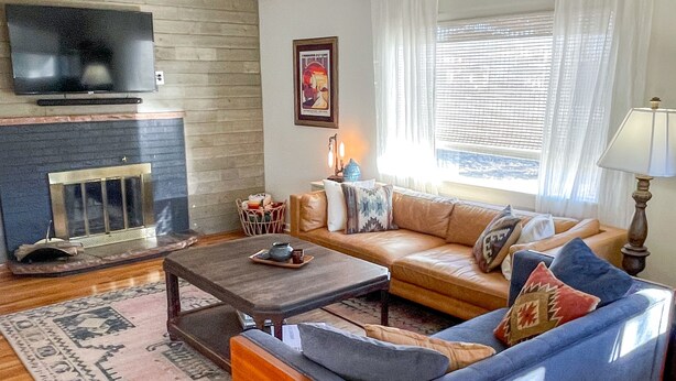Una sala de estar con sofá, mesa de centro y chimenea.