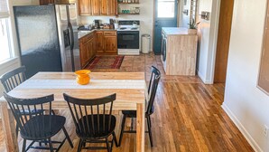 Una cocina compacta con armarios de madera, un refrigerador, un horno y una lavadora.