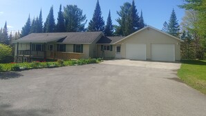 Ein zweistöckiges Haus mit Veranda, Garage und Auffahrt.