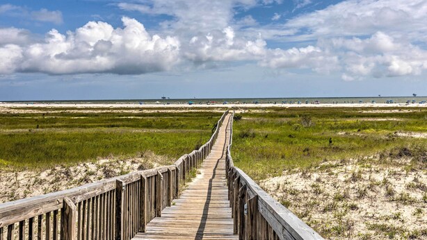 A wooden boardwalk leading to a beach with sand dunes and grassy areas. - Dauphin Island Condo w/ Pool, Balcony & Ocean View (Dauphin Island)