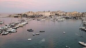 A marina with numerous boats docked, surrounded by buildings with a historical architectural style. - Appartamento Camera da Letto Vista Mare, 2 Bagni Parcheggio,spiaggia Solarium (Siracusa)
