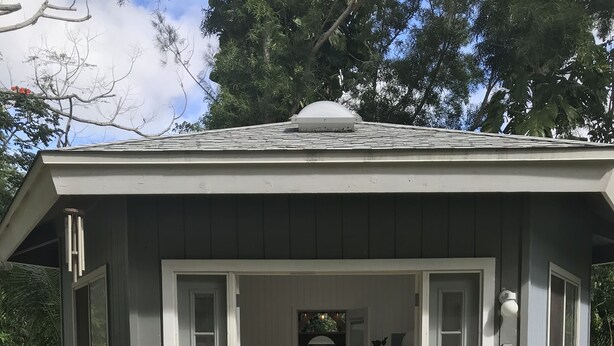 A small, single-story house with a porch, a bed, and a chair. - Sun Filled, Tropical Bungalow (Haleiwa)