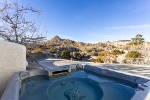 A hot tub with a view of a rocky hillside and a building in the distance. - Observatory, Game Room, Hot tub, Fire Pit, BBQ, 360° View at Observatory Retreat (Yucca Valley)