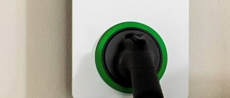 An AUTEL charging station with instructions and a green plug.