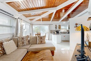 Relax in this spacious living area with a sofa, coffee table, and large window.