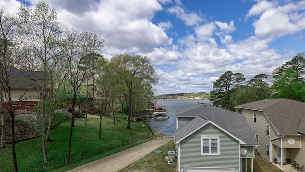 Un quartier résidentiel avec des maisons, une allée et une rivière où se trouve un quai pour bateaux.