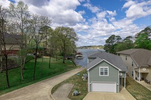 Un quartier résidentiel avec des maisons, une allée et une rivière où se trouve un quai pour bateaux.